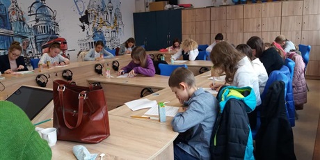Powiększ grafikę: Uczniowie piszą w sali lekcyjnej test konkursowy.