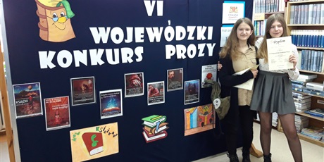 Powiększ grafikę: Uczennice pozują na tle napisu "Wojewódzki konkurs prozy".