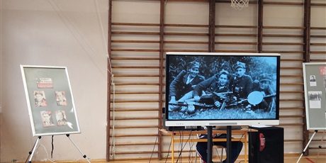 Powiększ grafikę: Sala gimnastyczna - dekoracja ze zdjęciami i filmem o Żołnierzach Wyklętych.