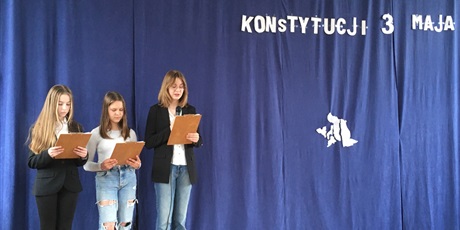 Powiększ grafikę: Trzy uczennice na tle niebieskiej planszy z napisem 232 rocznica uchwalenia konstytucji 3 maja