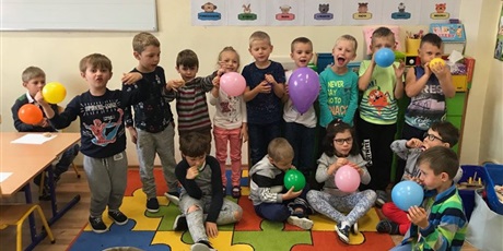 Powiększ grafikę: Uczniowie pozują z kolorowymi balonami.