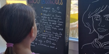 Powiększ grafikę: Uczennica ogląda plakaty