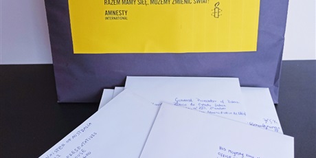 Powiększ grafikę: Na zdjęciu widać listy w kopertach zaadresowane do władz państw, które łamią prawa człowieka. Z tyłu test napis "Maraton Pisania Listów Amnesty International".