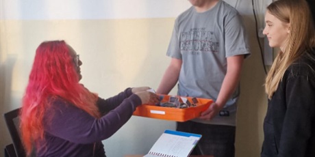 Powiększ grafikę: Uczniowie wręczający muffinki nauczycielom.