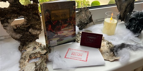 Powiększ grafikę: Zdjęcie przedstawia wystawę nawiązującą do "Dziadów" Adama Mickiewicza. Maski z kory drzewa, dramat "Dziady", pajęczyny, świece, pieczątka "narodowe czytanie 2026