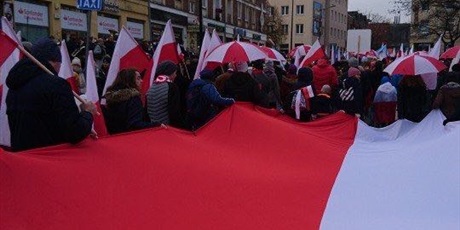Powiększ grafikę: SP nr 82 w Gdańsku podczas Parady Niepodległości z biało-czerwonymi flagami i parasolami. 