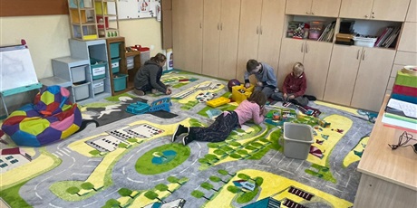 Powiększ grafikę: Dzieci bawiące się na nowym dywanie.