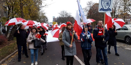 Powiększ grafikę: Społeczność SP82 podczas parady niepodległości - wszyscy trzymają biało-czerwone parasolki.