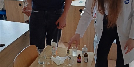 Powiększ grafikę: Na zdjęciu są widoczni uczniowie, którzy uczestniczą w zajęciach, ze studentami farmacji.