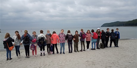 Powiększ grafikę: Klasa 5A ustawiona na przemian (raz przodem, raz tyłem) na plaży w Gdyni.