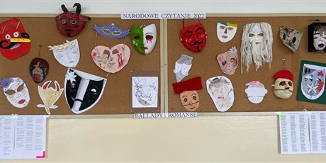 Powiększ grafikę: Zdjęcie przedstawia tablicę korkową z korytarza szkoły, na której wiszą różnorodne maski wykonane przez uczniów.