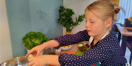 Powiększ grafikę: Dziewczynka przygotowuje sałatkę warzywną.