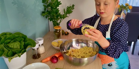 Powiększ grafikę: Dziewczynka przygotowuje sałatkę warzywną.