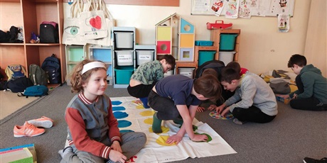 Powiększ grafikę: Uczniowie grają w grę Twister. 